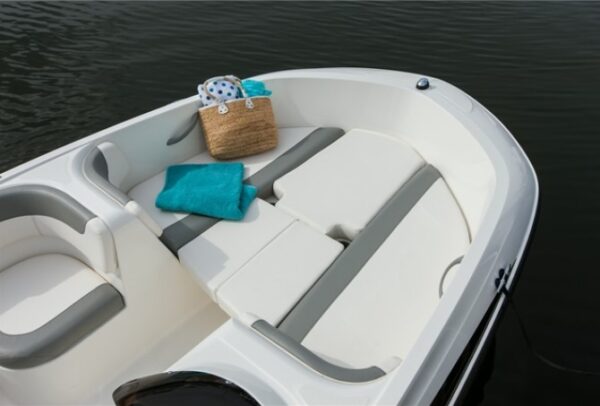 a bag and a towel on small filler cushion at back of the boat